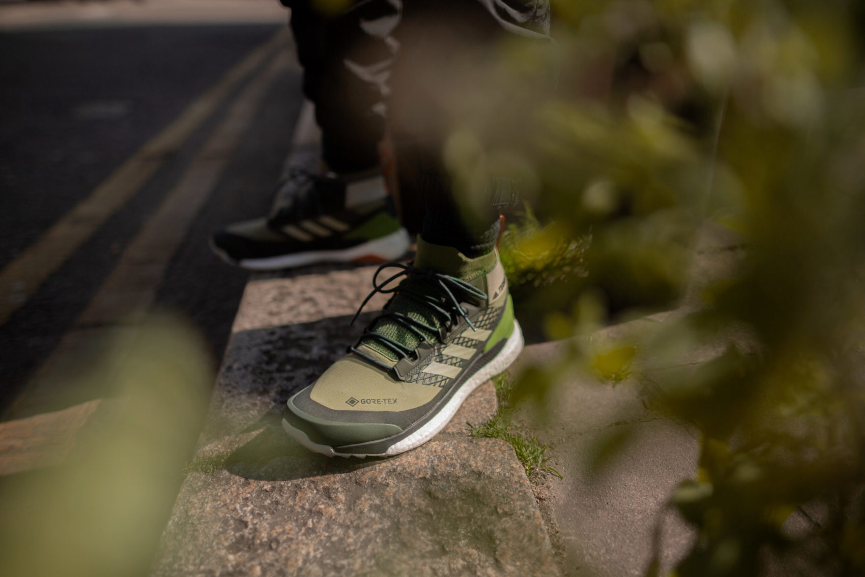 A creative promotional photo taken by I Heart Studios showcasing the detail of a man's leg wearing a pair of sneakers.