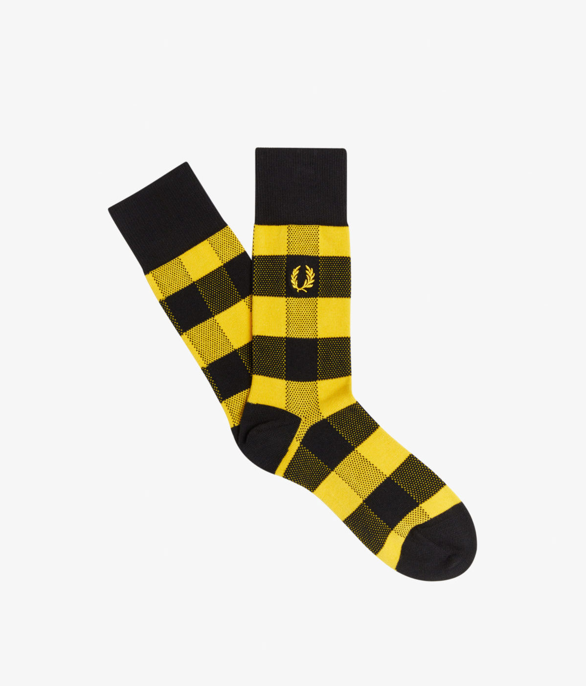 A flat lay fashion image showcasing a pair of black and yellow socks from Fred Perry, professionally captured by I Heart Studios.