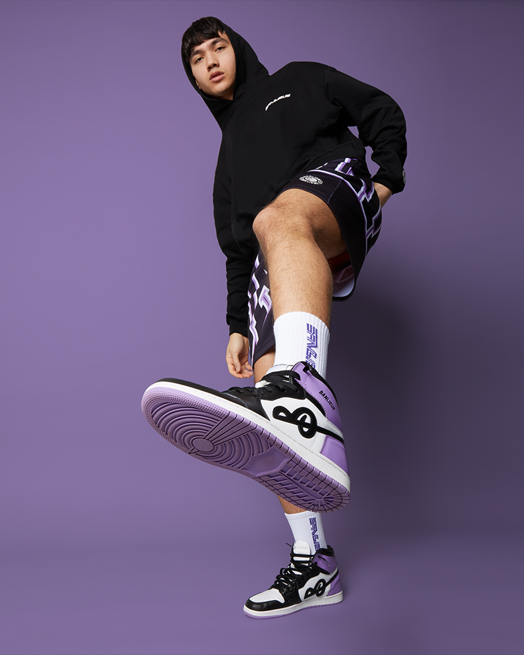 A male fashion model wearing a black and purple outfit, captured by I Heart Studios for eCommerce model fashion photography.