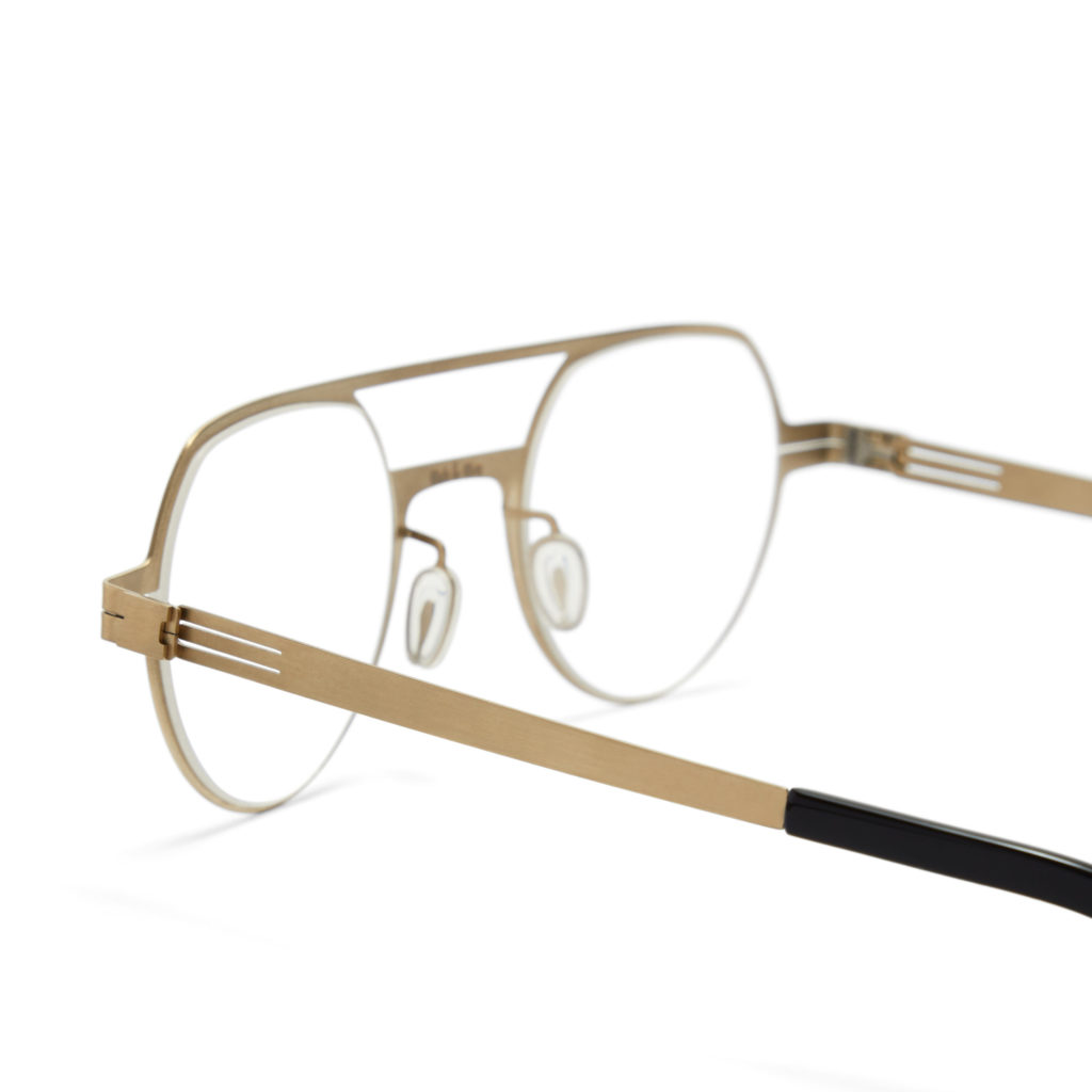 A packshot fashion image showcasing a golden-framed eyeglasses, shot with a dynamic angle, professionally captured by I Heart Studios.