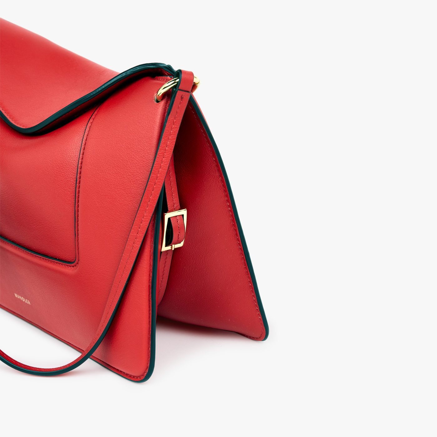 A packshot fashion image showcasing a red handbag with a dynamic angle, professionally captured by I Heart Studios.